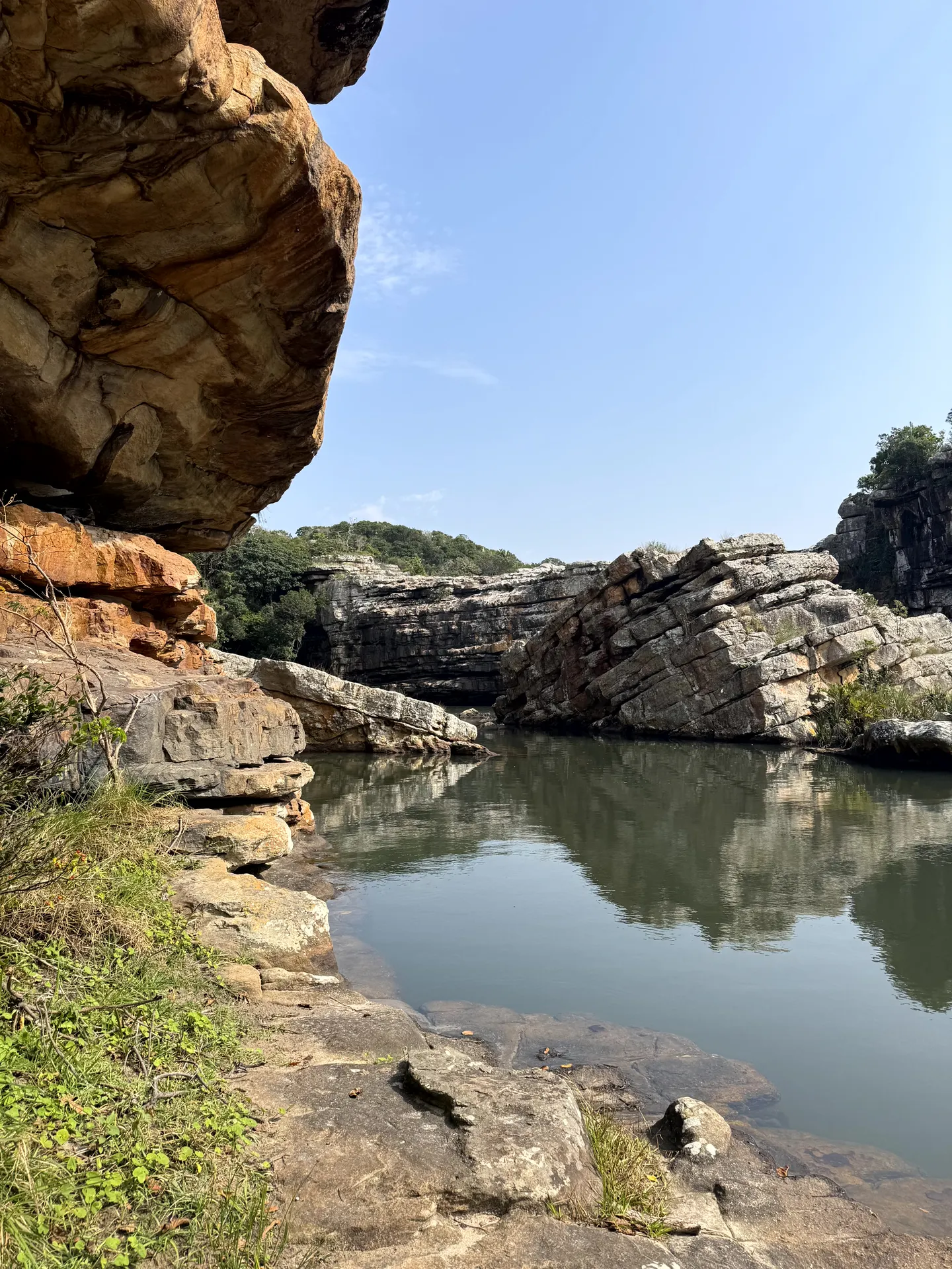 Dramatic rock formations surrounding serene river pool