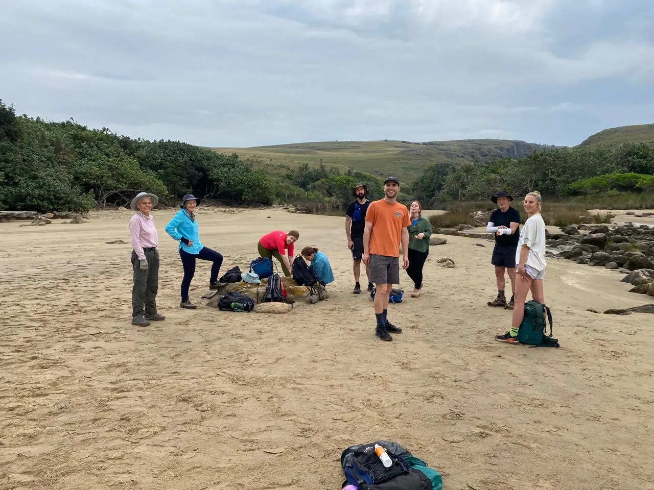 Hiking group taking a break on sandy beach