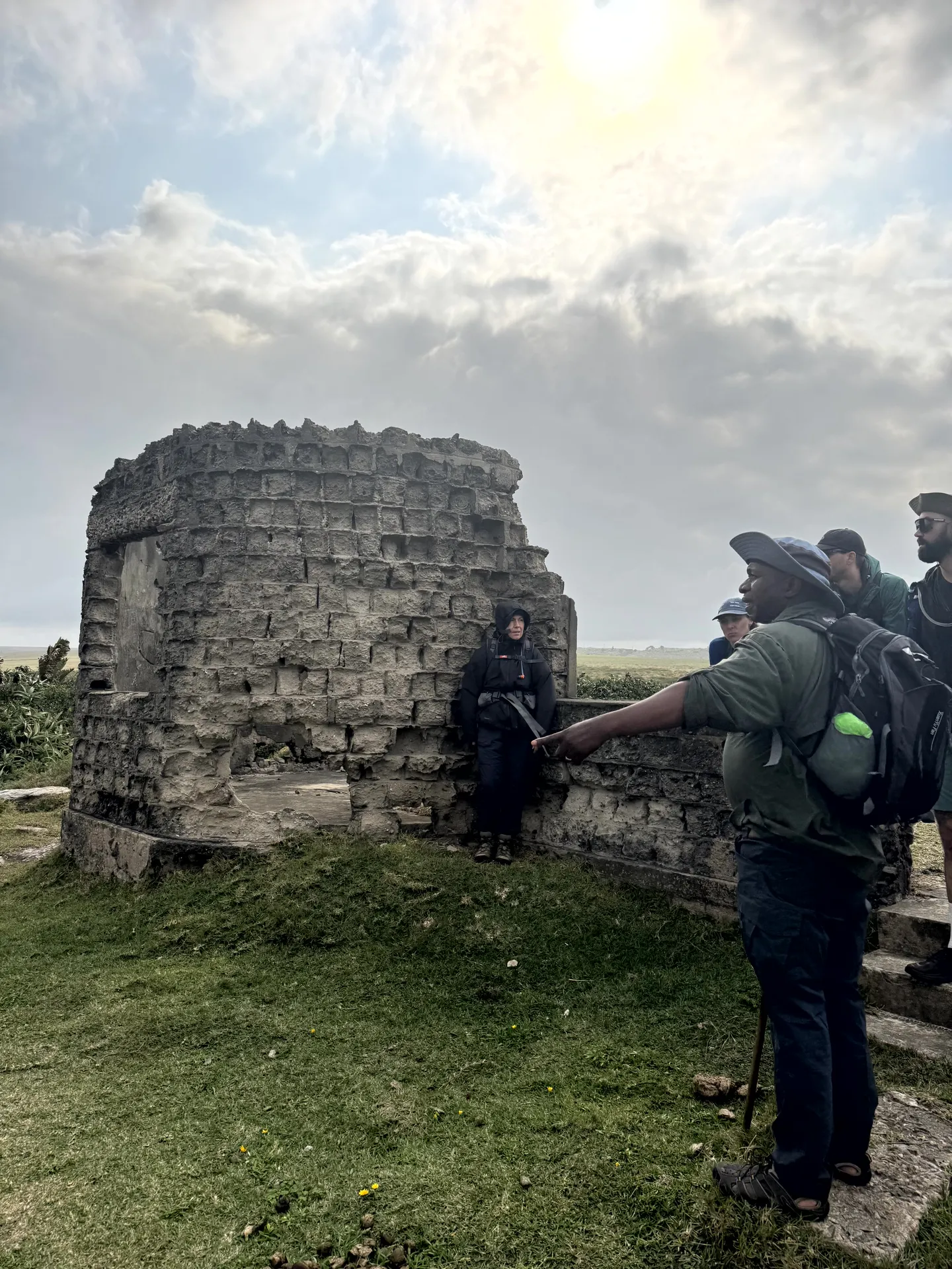 Group touring historic stone tower ruins with guide