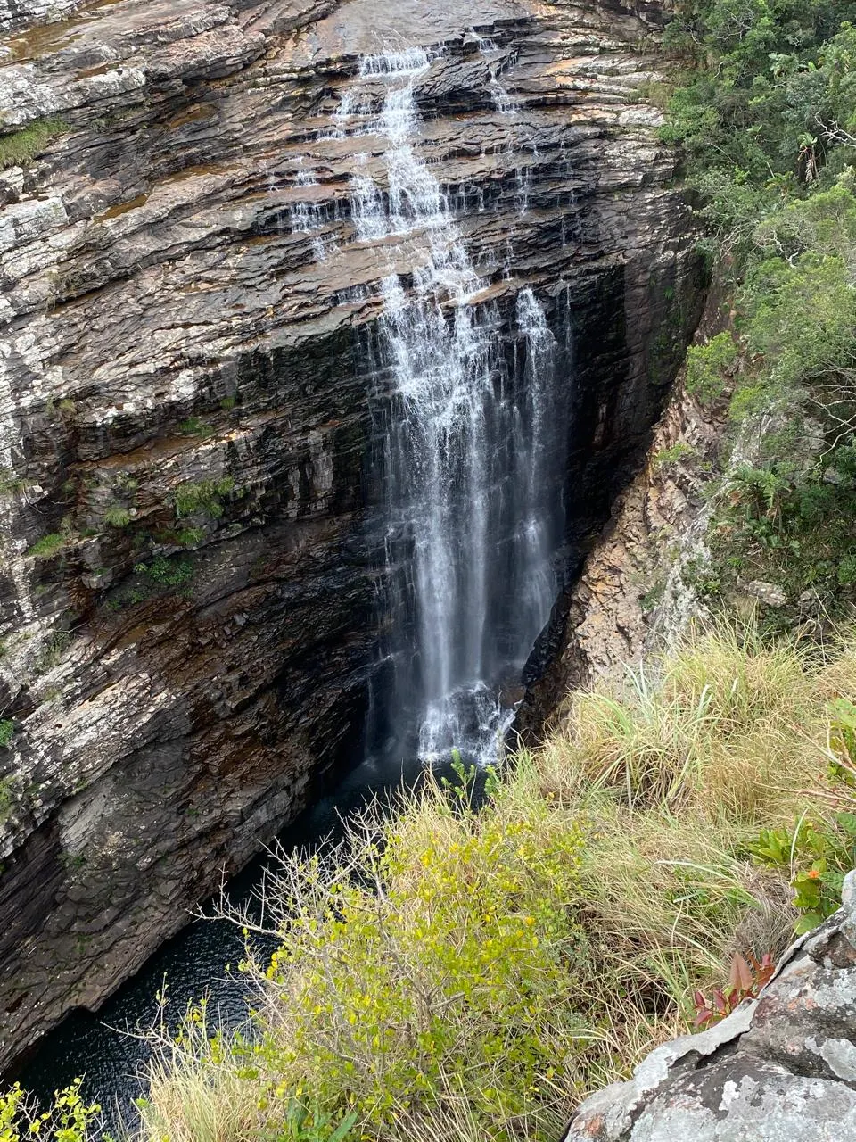 Tall waterfall cascading down dark rock face